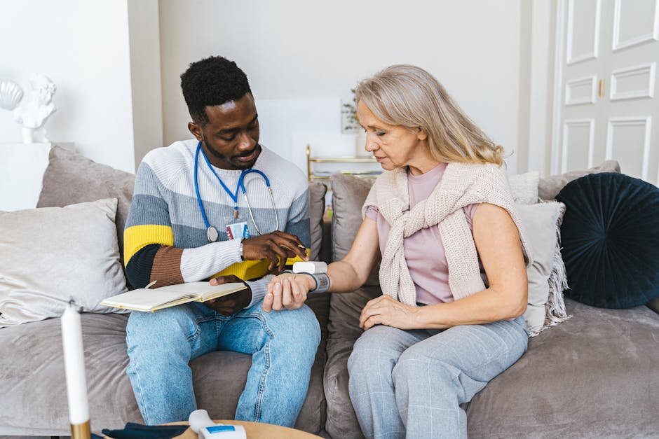 Healthcare professional checking blood pressure of elderly woman in a cozy indoor setting.
